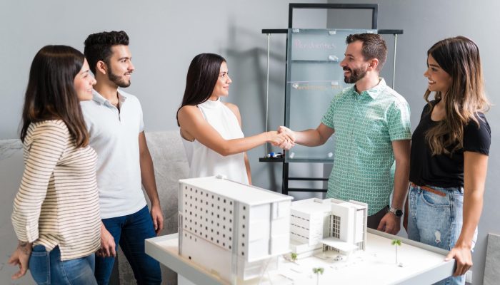 business-partners-shaking-hands-with-engineer-by-architectural-model-meeting